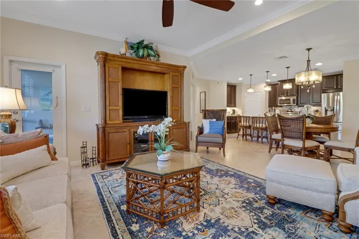 Living area featuring a ceiling fan, recessed lighting, ornamental molding, and light tile patterned floors