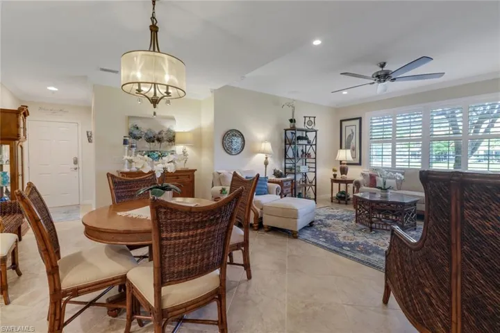 Dining room with baseboards, recessed lighting, crown molding, and ceiling fan with notable chandelier