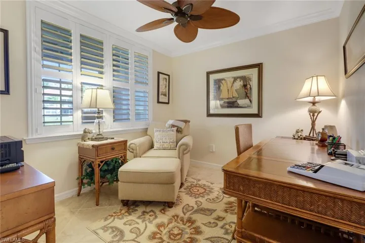Office area featuring light tile patterned floors, ornamental molding, baseboards, and a ceiling fan
