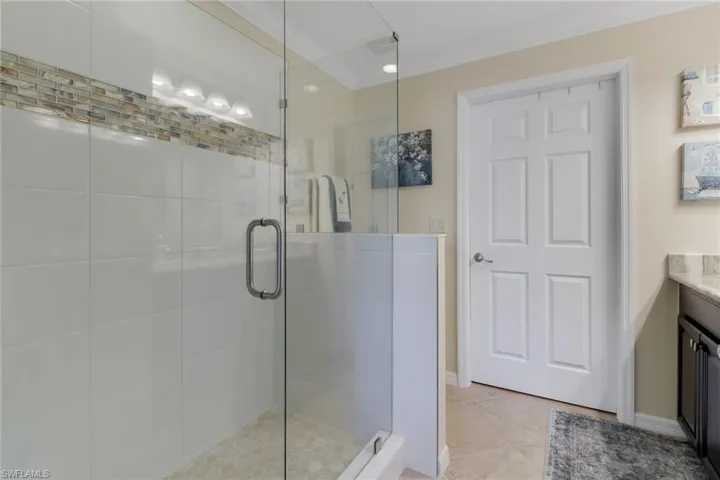 Full bathroom featuring tile patterned floors, vanity, a shower stall, baseboards, and ornamental molding