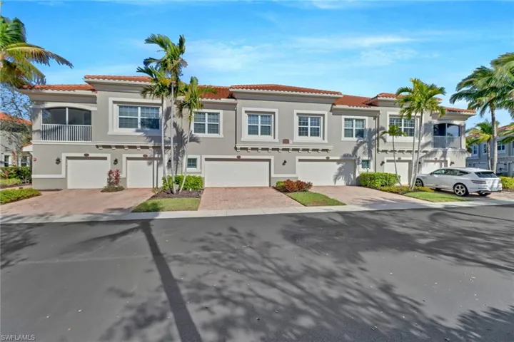 View of front of property featuring a tiled roof, driveway, stucco siding, and an attached garage