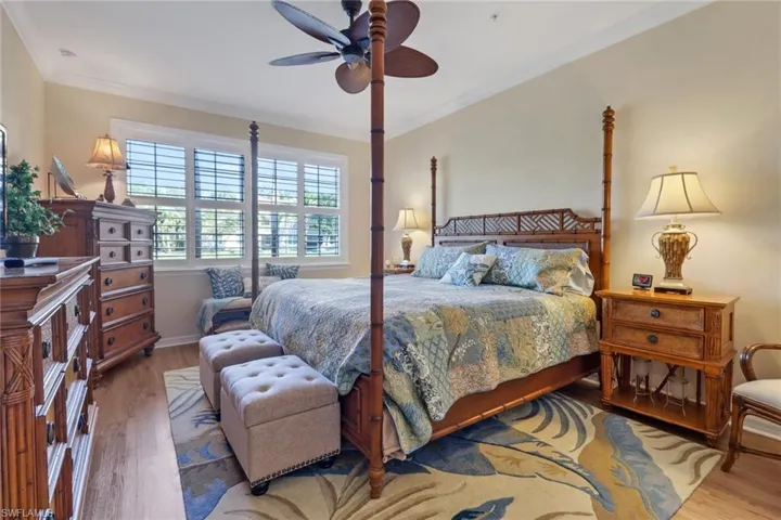 Bedroom featuring ornamental molding, ceiling fan, and wood finished floors