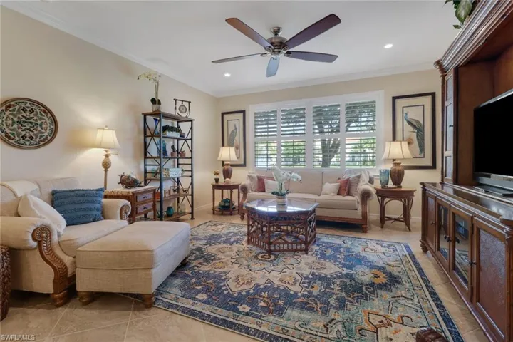 Living area with recessed lighting, ornamental molding, baseboards, light tile patterned flooring, and ceiling fan