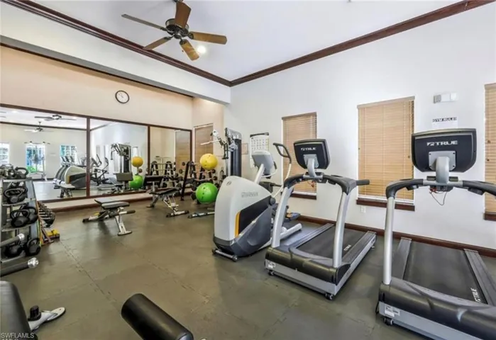 Workout area featuring baseboards, ornamental molding, and a ceiling fan