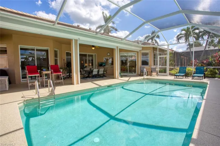 View of swimming pool with a patio area, screen enclosure, and ceiling fan