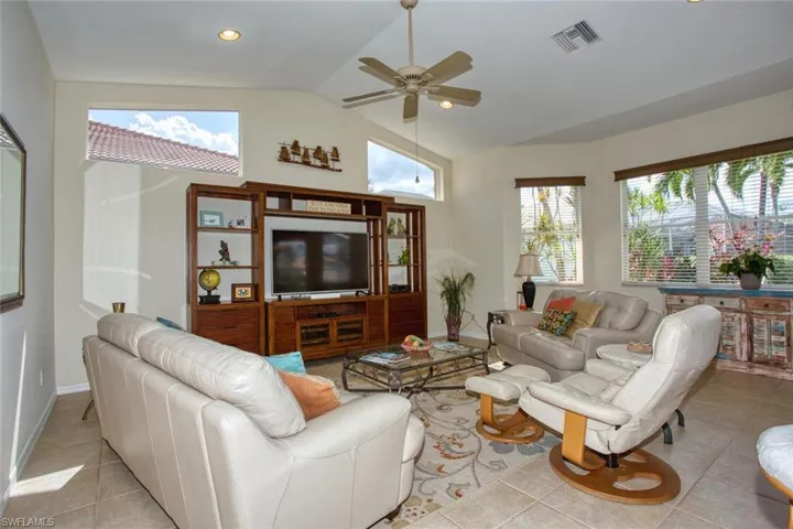 Tiled living room with high vaulted ceiling, and plenty of natural light