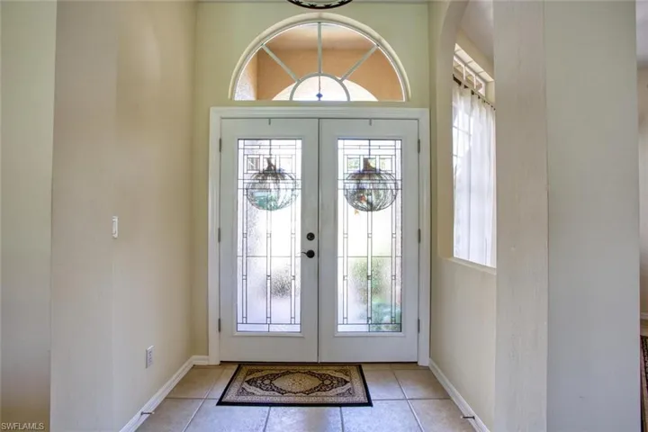 Foyer entrance featuring french doors and light tile patterned floors