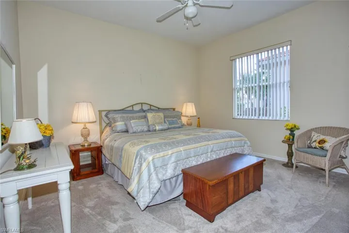 Carpeted bedroom featuring ceiling fan