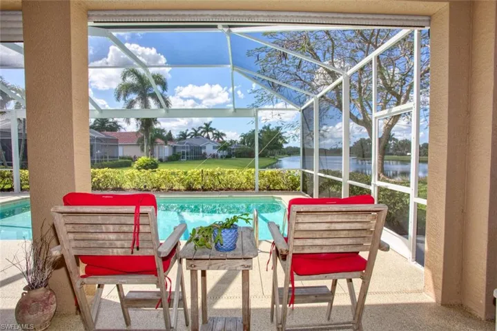 View of swimming pool with a water view, a patio area, and a lanai