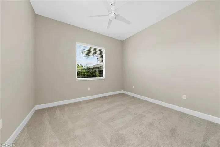 Carpeted empty room with ceiling fan