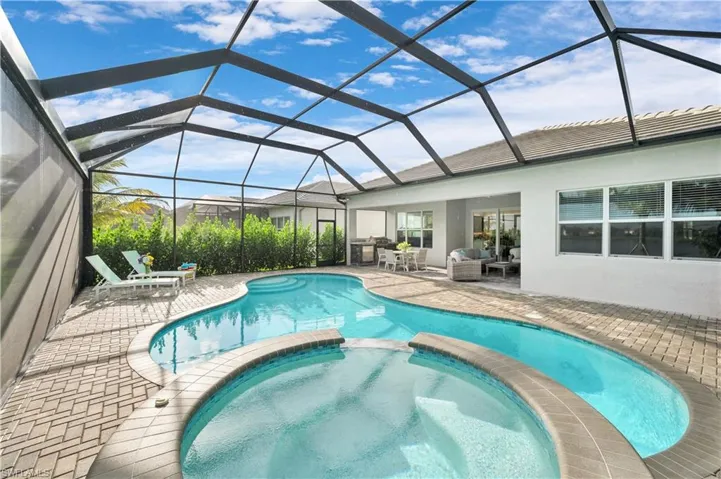 View of swimming pool featuring an outdoor living space, an in ground hot tub, a patio area, and a lanai