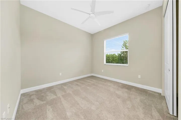 Spare room featuring ceiling fan and light carpet