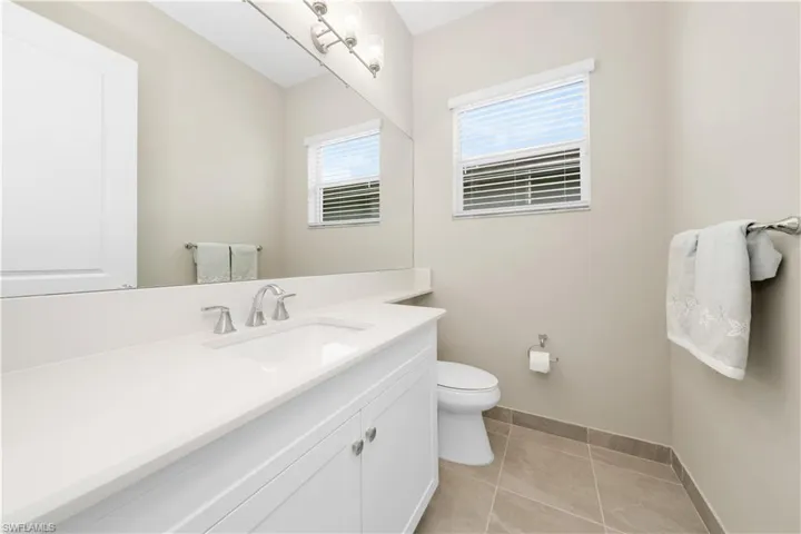 Bathroom featuring toilet, vanity, and tile patterned flooring