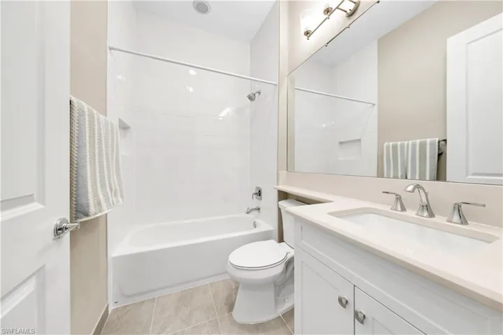 Full bathroom featuring vanity, shower / tub combination, toilet, and tile patterned flooring
