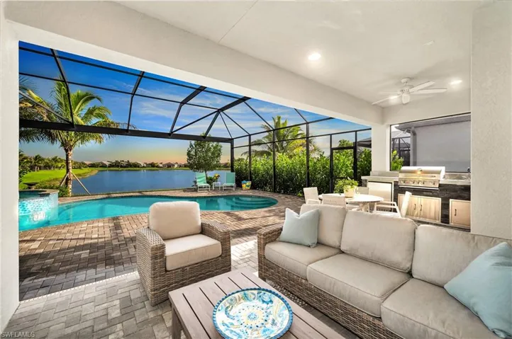 Patio terrace at dusk featuring exterior kitchen, an outdoor hangout area, screened enclosure, area for grilling, and ceiling fan