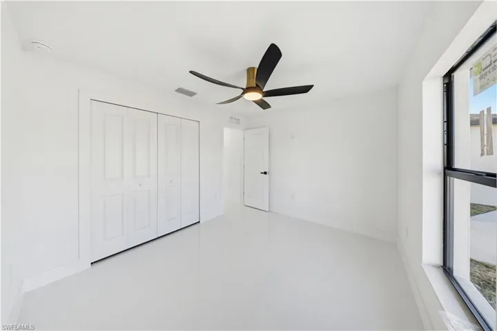 Unfurnished bedroom with ceiling fan and a closet