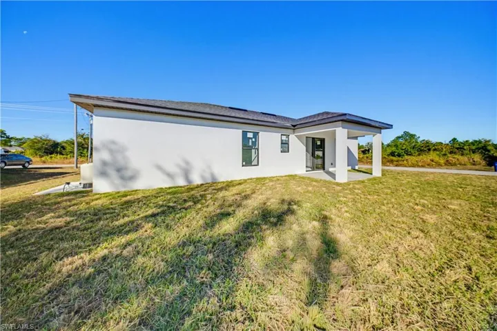Back of property with stucco siding, a yard, and a patio