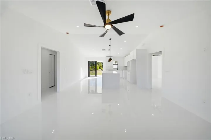 Unfurnished living room featuring recessed lighting and vaulted ceiling