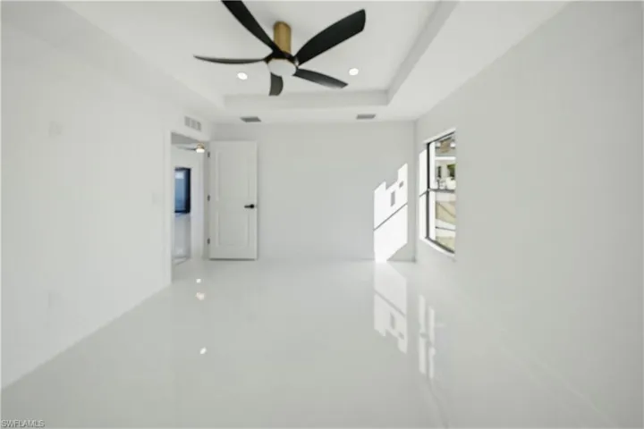 Empty room featuring recessed lighting, a raised ceiling, and ceiling fan