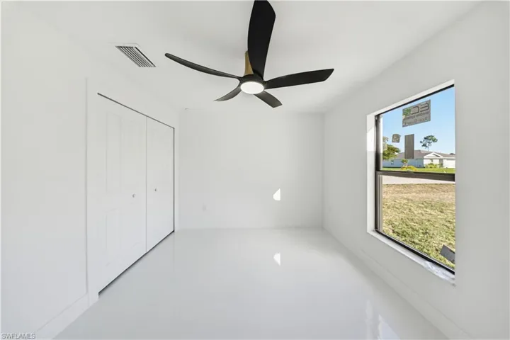 Unfurnished bedroom with ceiling fan and a closet