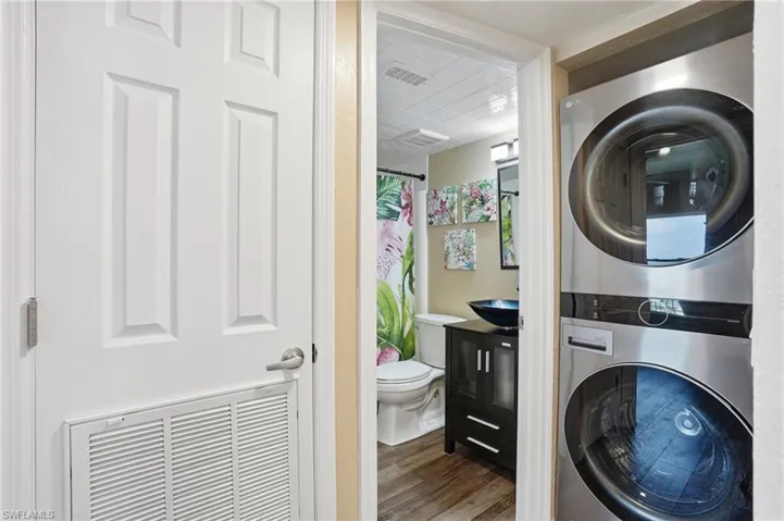Dedicated laundry area featuring a stacked washer and dryer unit - Virtually Edited Image