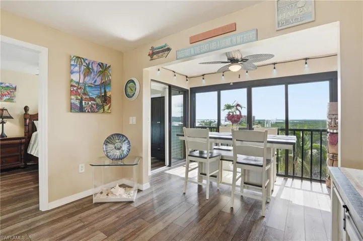 Dining area with panoramic windows, wood-finish flooring, and track lighting - Virtually Edited Image