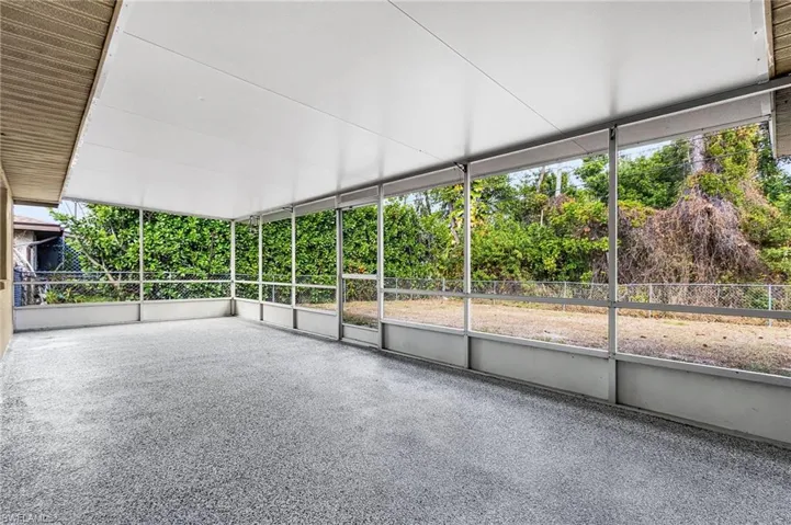 Screened lanai with doorway leading to the back yard.