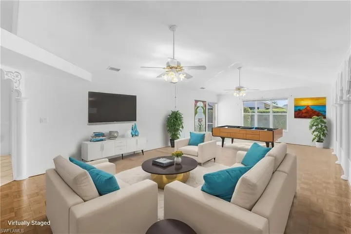 Virtually stagedLiving area featuring pool table, parquet flooring, a ceiling fan, and lofted ceiling