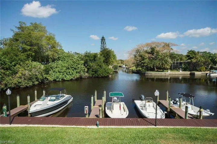 Dock area featuring a water view and view of wooded area