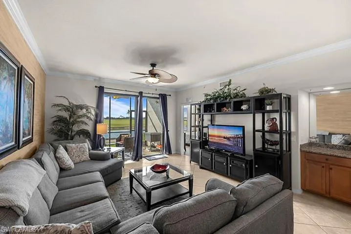 Tiled living room featuring ceiling fan and crown molding