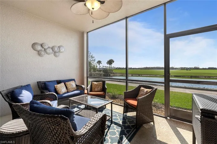 Sunroom featuring ceiling fan and a water view