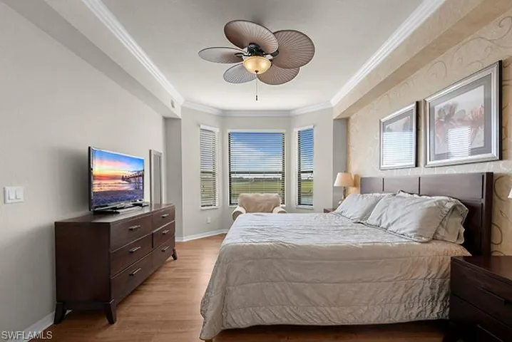 Bedroom featuring ceiling fan, light hardwood / wood-style floors, and ornamental molding