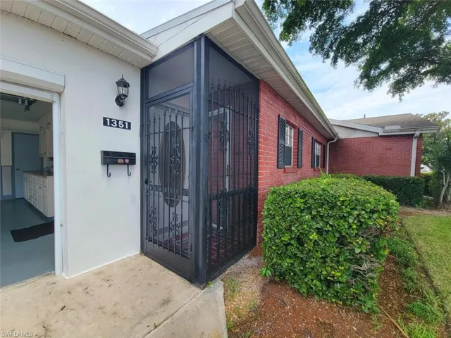 Doorway to property featuring brick siding