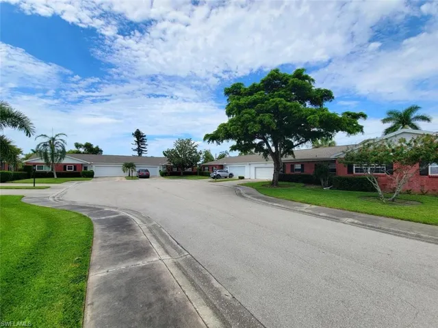 View of asphalt road featuring sidewalks and curbs