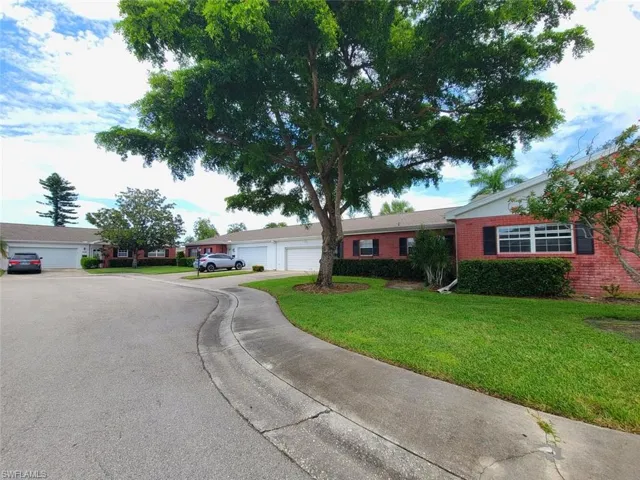 Ranch-style house featuring a front lawn, brick siding, and driveway