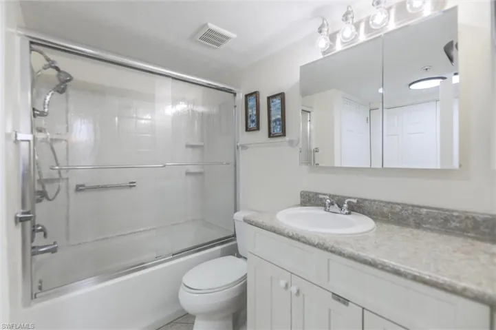 Bedroom featuring light tile patterned floors, baseboards, and a ceiling fan