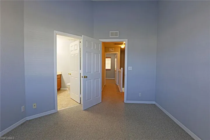 Unfurnished bedroom featuring carpet floors and ensuite bath