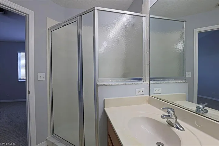 Full bath featuring a stall shower, vanity, and light colored carpet