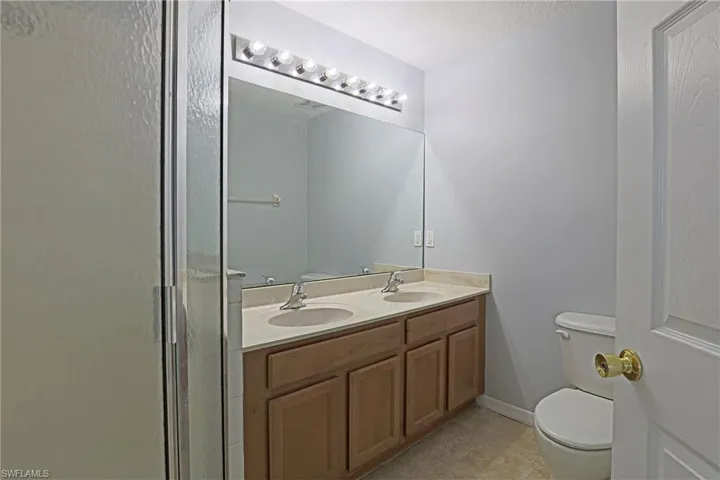 Bathroom featuring double vanity and a shower stall