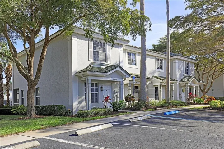View of front facade with stucco siding and uncovered parking