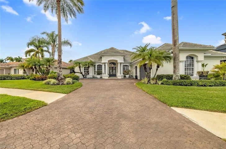Mediterranean / spanish-style house featuring stucco siding, a front lawn, decorative driveway, a garage, and french doors