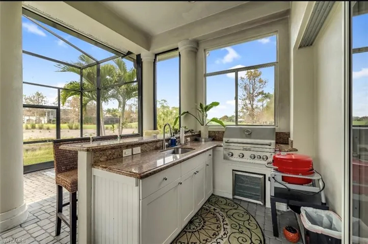 Sunroom / solarium with wine cooler and healthy amount of natural light