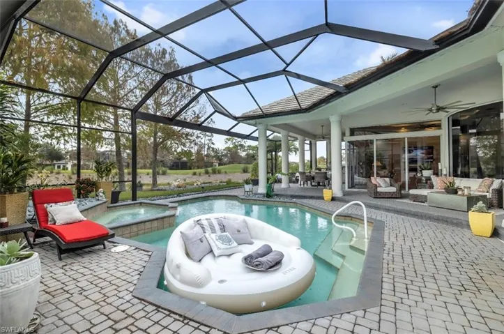 View of swimming pool with a patio area, a pool with connected hot tub, an outdoor living space, and a sunroom