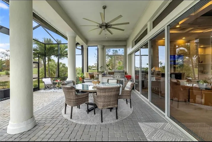 Sunroom featuring outdoor dining area, a ceiling fan, a patio area, and exterior kitchen