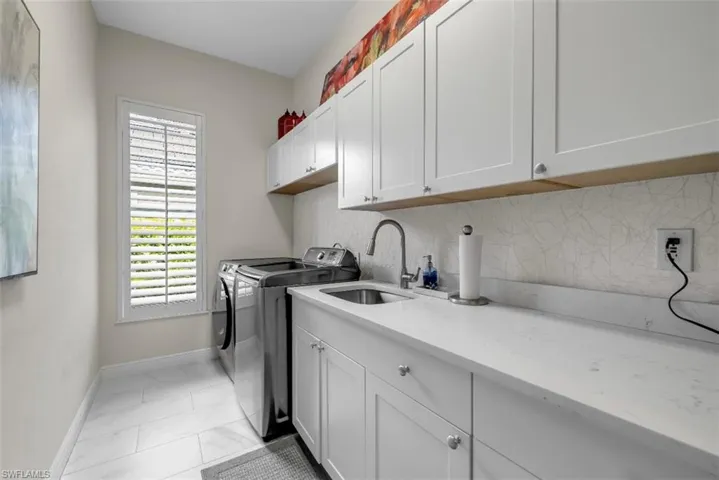 Washroom featuring washing machine and clothes dryer and cabinet space