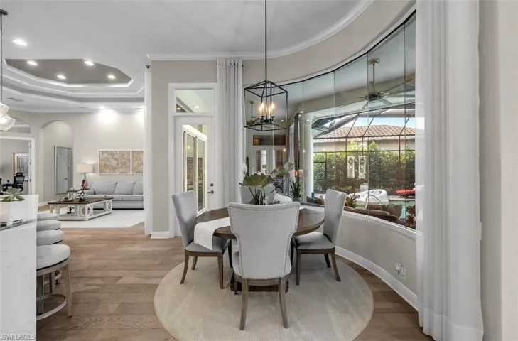Dining area featuring ornamental molding, light wood-style flooring, recessed lighting, a chandelier, and arched walkways