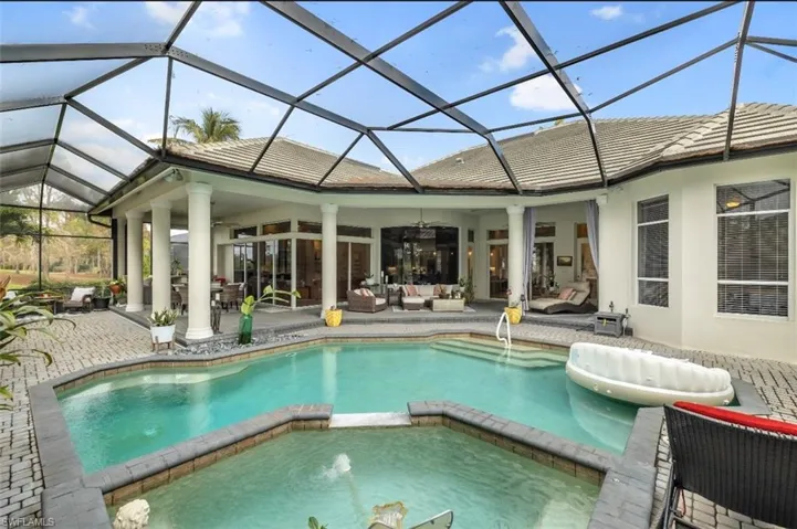 View of pool with an outdoor living space, a pool with connected hot tub, a patio area, and a sunroom