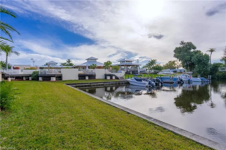 View of dock featuring a water view and a lawn