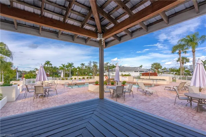 Wooden deck with a patio area, a gazebo, and a community pool