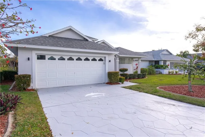 Ranch-style home featuring a front yard and a garage